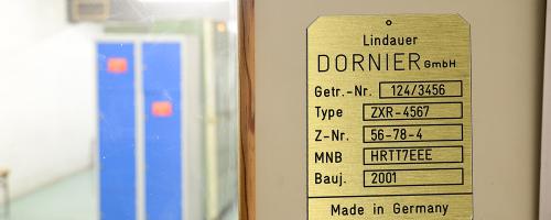 Gravur der Serien- und Typennummern auf einer Identifikationsplakette aus Gravostral™-Material